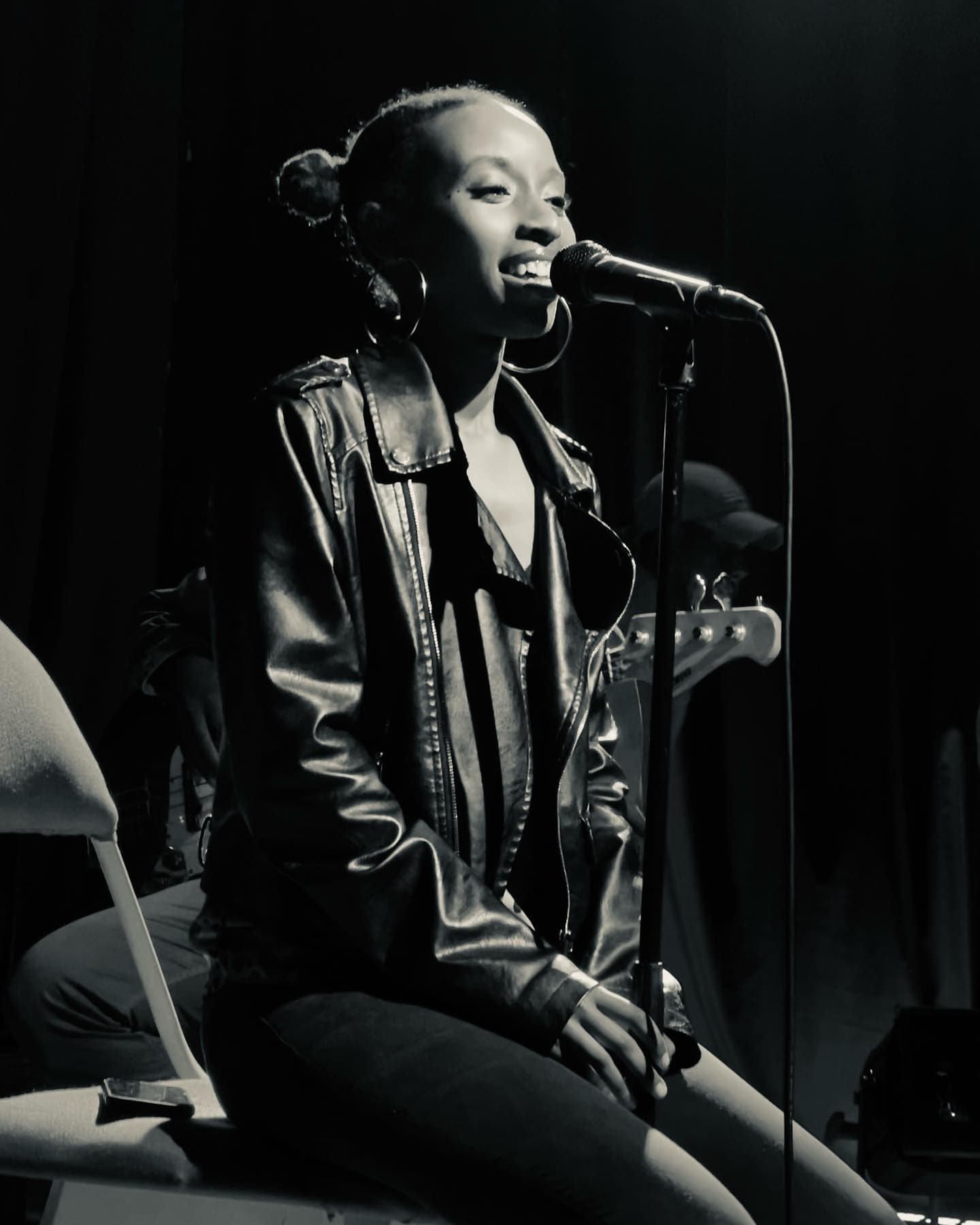 Young female Rwandan vocalist singing with stage microphone in live performance